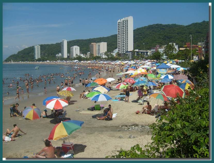 Praia Brava de Caiobá movimentada com banhistas e prédios à beira-mar